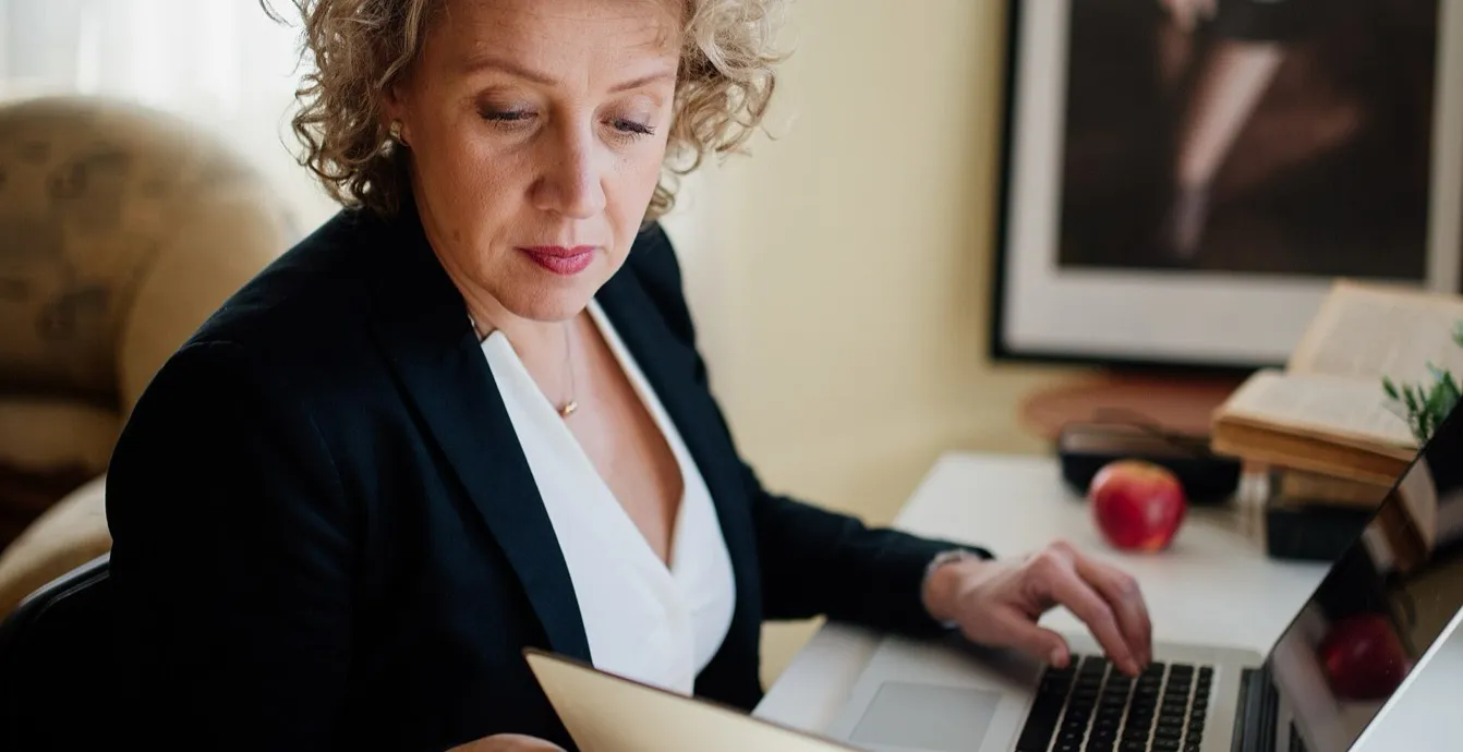 Profesionista trabajando en su laptop con documentos para emitir facturas